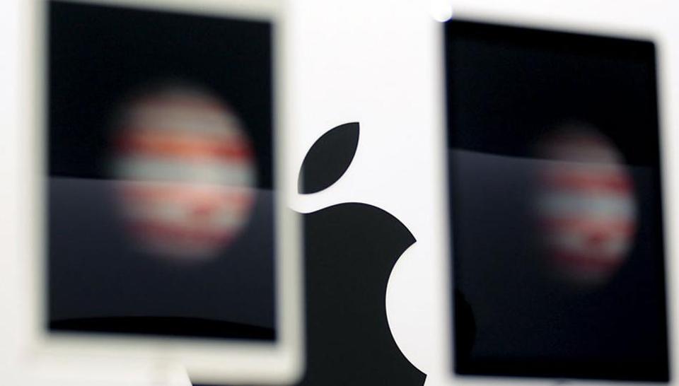 The Apple logo is seen behind new Apple iPad Pros on display during an Apple media event in San Francisco. Photo: Reuters