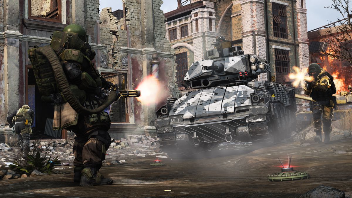 seorang pemain yang mengenakan baju besi Juggernaut yang berat menghadapi pemain lain yang menembakkan senapan serbu dan tank dalam tangkapan layar dari Call of Duty: Modern Warfare (2019)