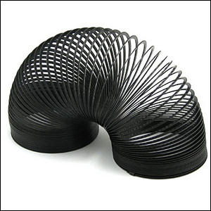 Slinky hitam, terbuka mengipasi, di atas meja putih