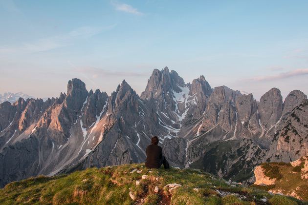 Foto pemandangan: Pegunungan dan seseorang yang duduk di tepi