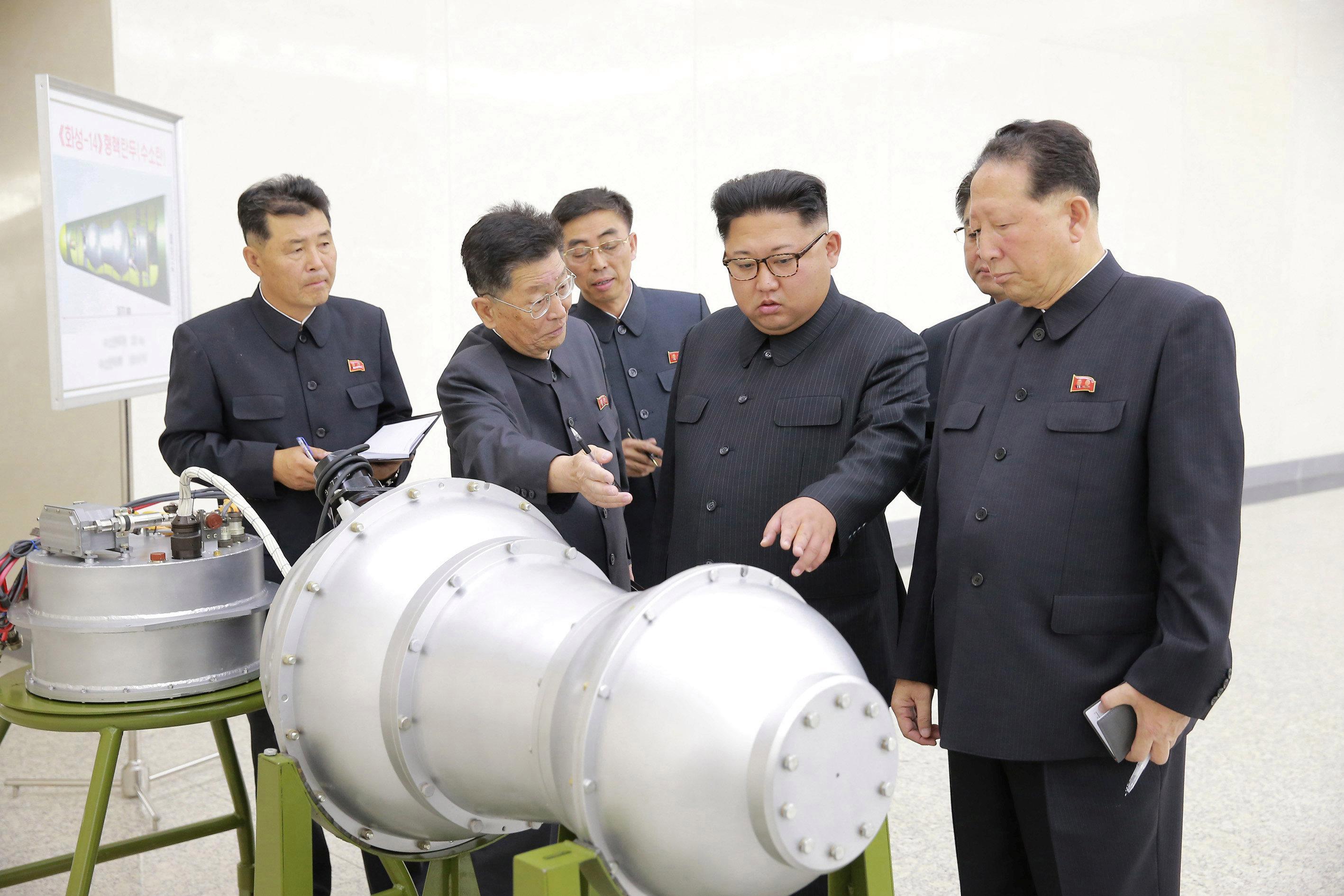  Pemimpin Korea Utara Kim Jong-un memeriksa apa yang diklaim sebagai bom hidrogen yang pas di kerucut hidung misil minggu lalu